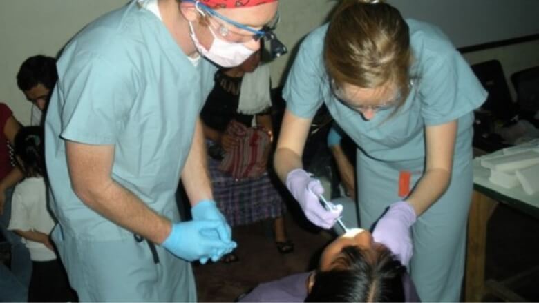 Doctor Altenbach and dental team member performing a dental exam on a child