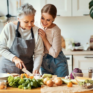 Senior woman and adult daughter preparing healthy meal