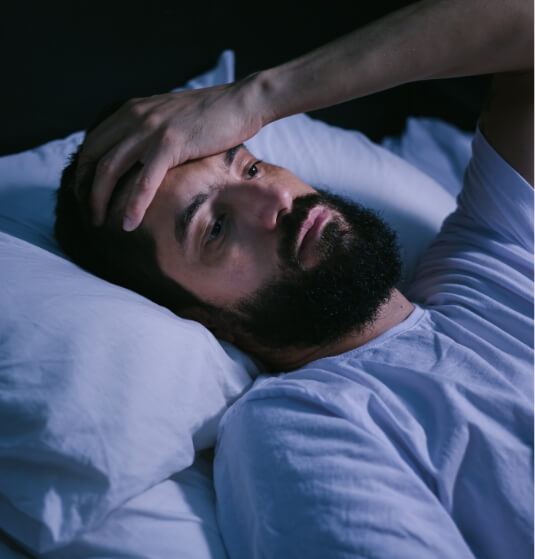 Man lying awake in bed and needing sleep apnea treatment in Jacksonville