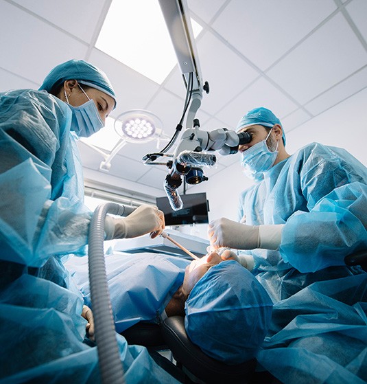 a dentist and assistant placing a dental implant