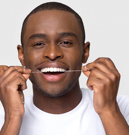 Closeup of man smiling while flossing